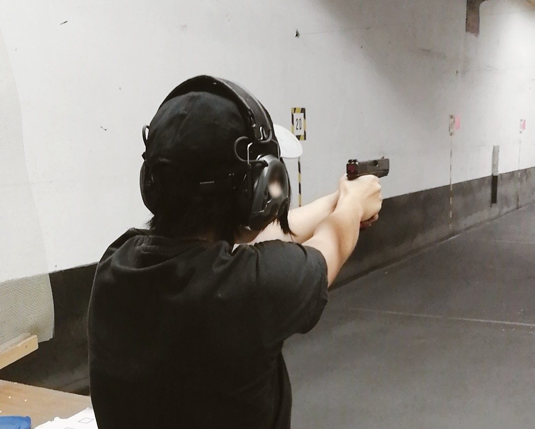 Teilnehmerin von hinten im Anschlag mit der Kurzwaffe.
