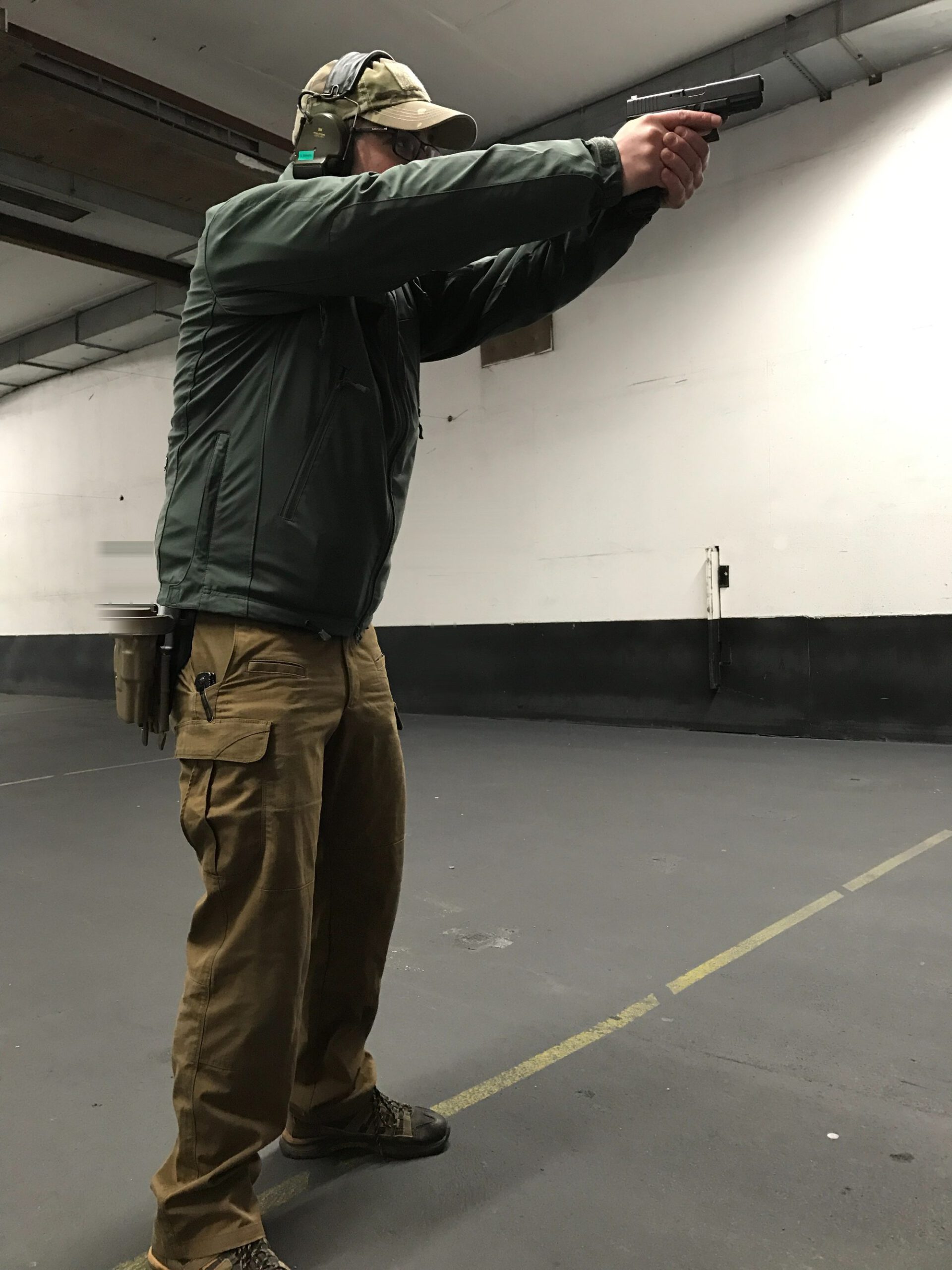 Schütze von der Seite im Anschlag mit der Kurzwaffe auf der 15-Meter-Marke.
