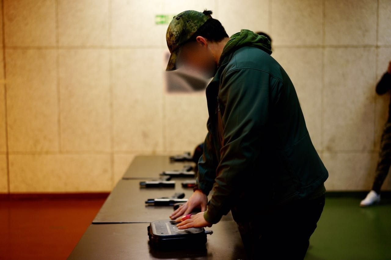 Teilnehmer legt am Schießstand die Kurzwaffe ab